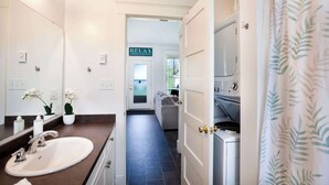 A modern bathroom with a sink, mirror, and a 'RELAX' sign on the door.