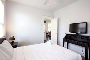 Une chambre d’hôtel avec un lit, une télévision, un bureau et une lampe.