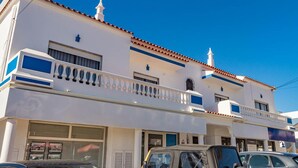 A two-story building with a white facade, red-tiled roof, and a balcony with balustrades. - Seaside Charm in Gale - 2 Bedroom W/big Terrace (Albufeira)