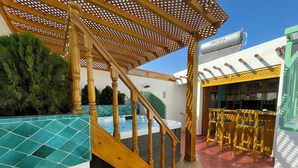 A wooden staircase leading to a pool area with a pergola overhead. - Riad Madinina (Marrakech)
