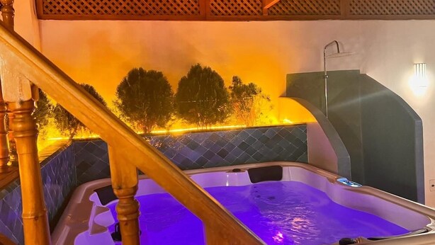 A hot tub with a wooden staircase and a view of trees in the background. - Riad Madinina (Marrakech)