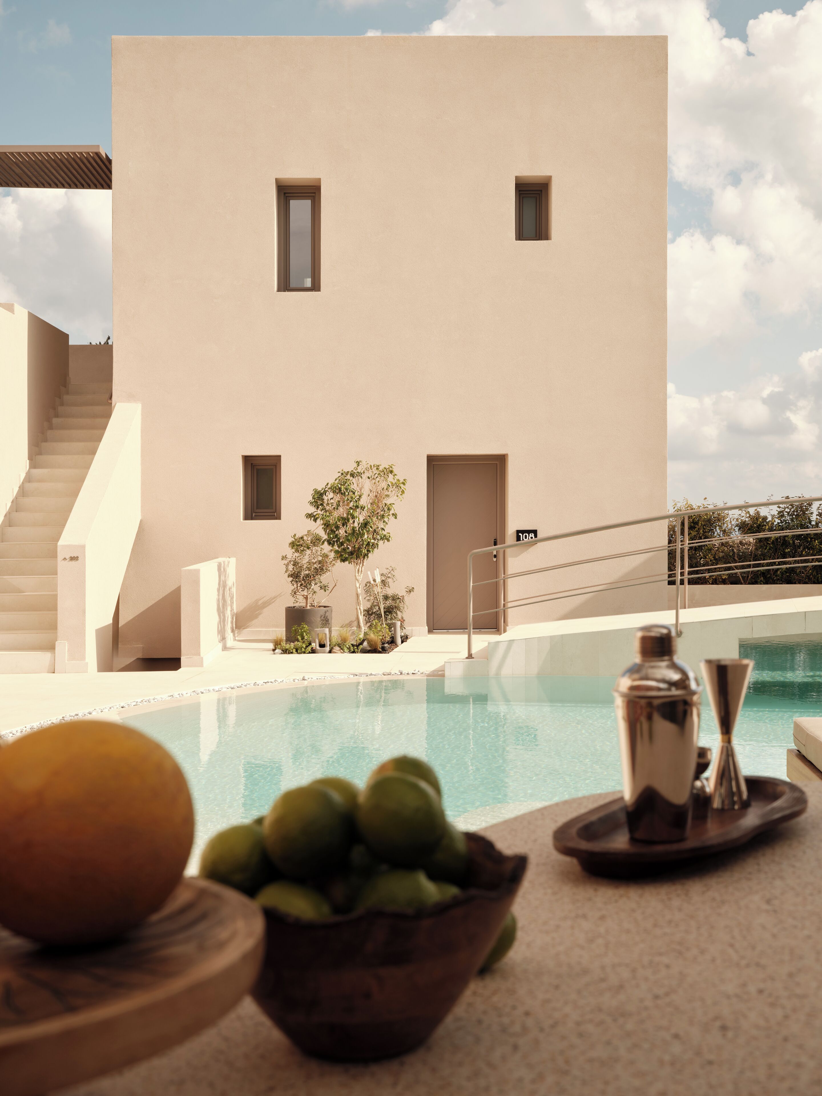 A modern building with a pool, a staircase, and a view of the sky.