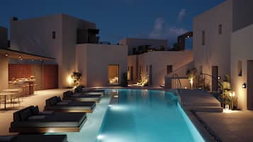 Una piscina al aire libre de temporada, sombrillas