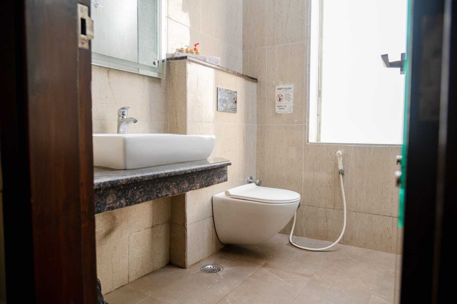 Un baño con lavamanos blanco, inodoro y ducha.