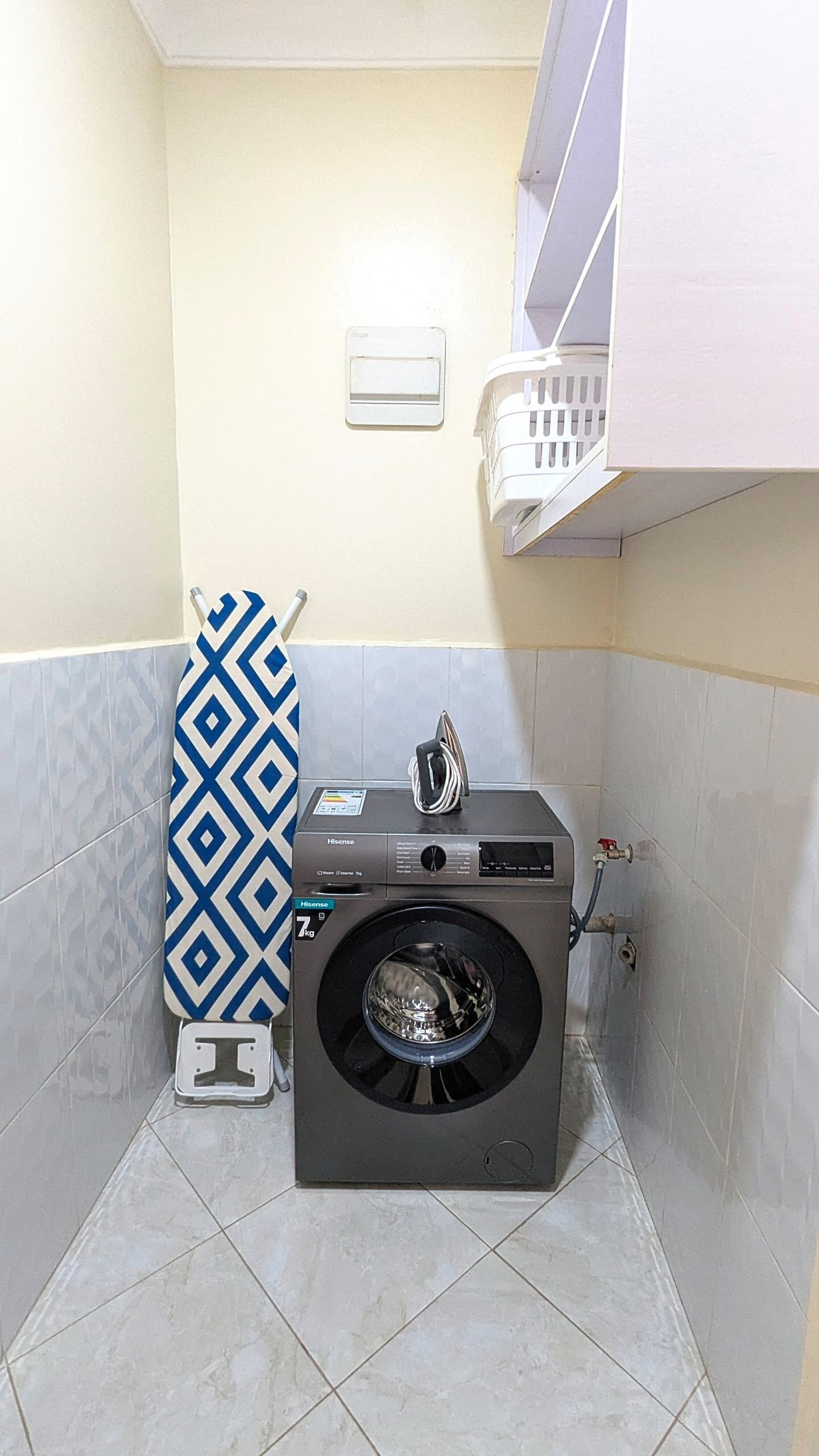 Ein kleines Badezimmer mit Waschmaschine, Handtuchhalter und Toilette.