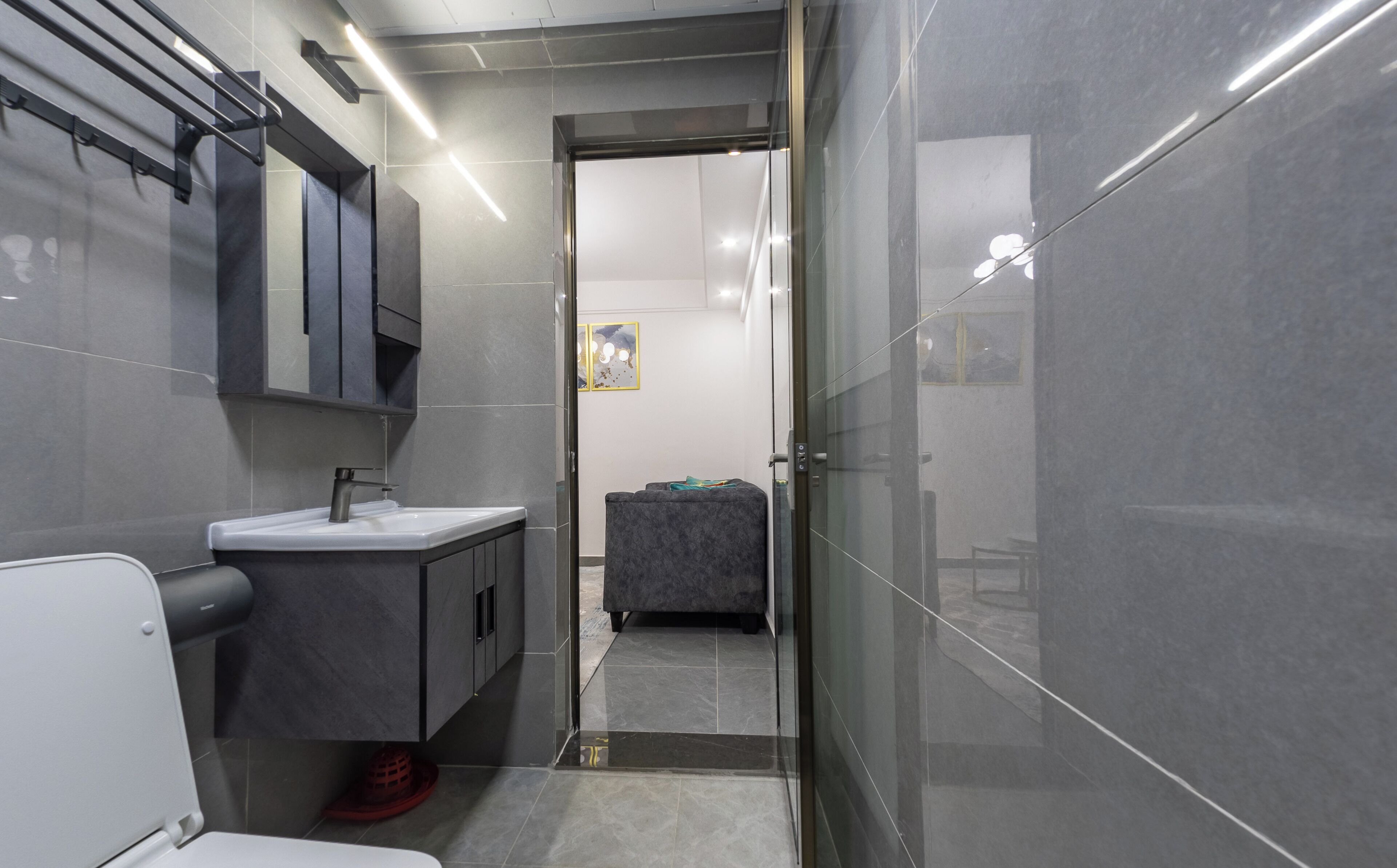 A modern bathroom with a sink, mirror, and toilet.