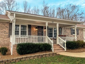 A two-story house with a covered porch, brick exterior, and a number '110' on the front. - Luxury 6,000+ sq ft Hideaway with Heated Pool, Spa, & Sauna - near Greenville (Taylors)