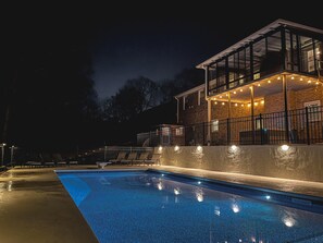 A swimming pool with lounge chairs and a covered patio area with string lights. - Luxury 6,000+ sq ft Hideaway with Heated Pool, Spa, & Sauna - near Greenville (Taylors)