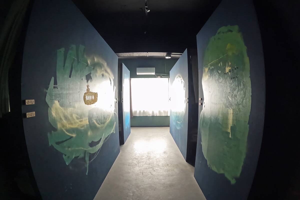 A hallway with blue walls and a light source at the end.