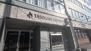 The exterior of the Tasogare Hostel with a sign indicating the direction to the room service area. - TASOGARE HOSTEL (Hakodate)