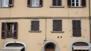 A building with multiple windows, a storefront with a sign, and a door.