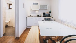 A compact kitchen with white cabinets, a microwave, and a coffee maker.