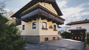 A traditional chalet with a balcony, a gravel driveway, and a clear sky. - Areit Apartments - Top 3 (Zell am See)