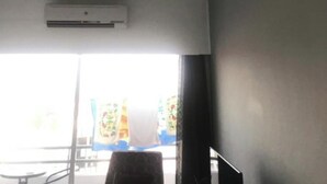 A room with a ceiling fan, an air conditioning unit, and a window with curtains. - Great views apartment. (Limassol)