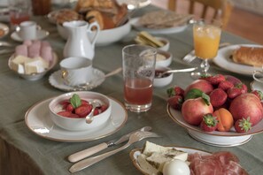 A breakfast table with various food items, including fruits, pastries, and beverages. - La Maison des Monts d'or (Saint-Germain-au-Mont-d'Or)