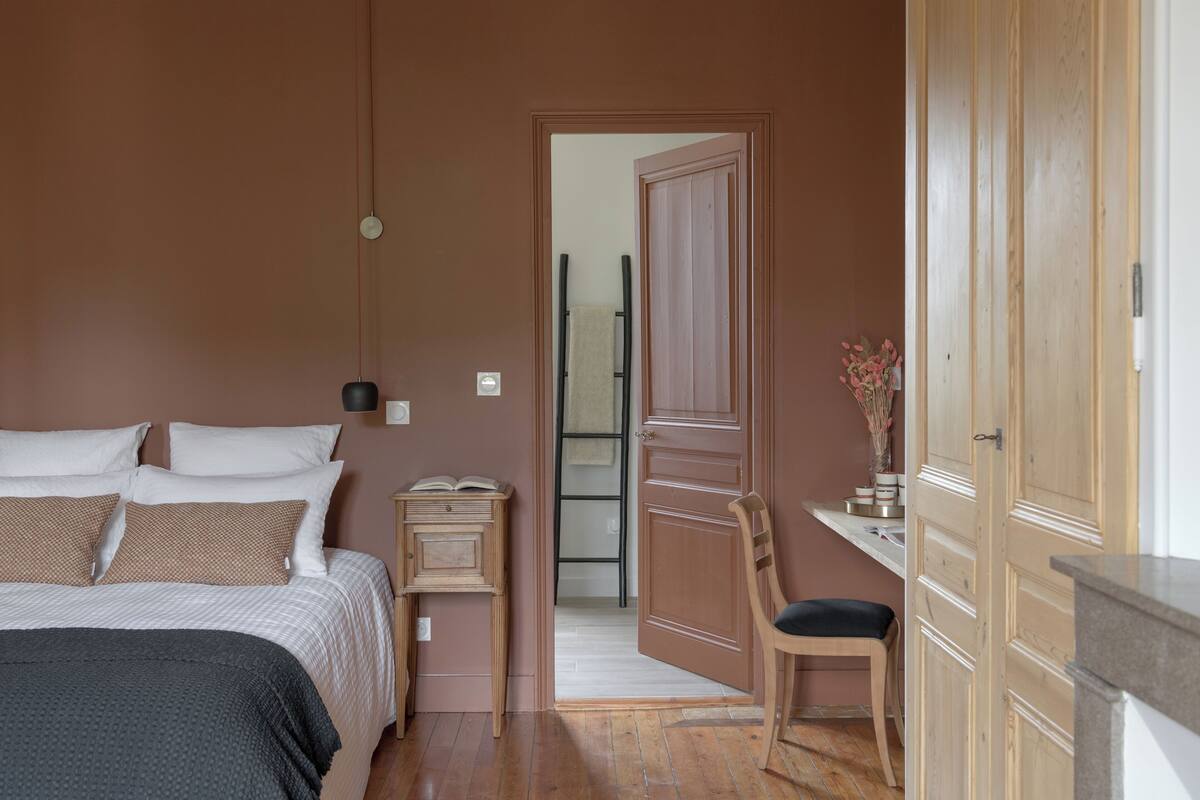 A bedroom with a bed, bedside table, and a chair.