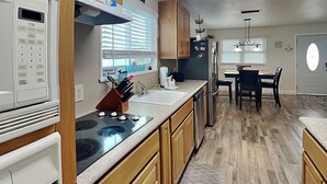 Une cuisine moderne avec des meubles en bois, un réfrigérateur en acier inoxydable et un four encastré.