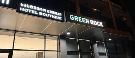 A hotel named "Green Rock" with a modern facade and large windows.