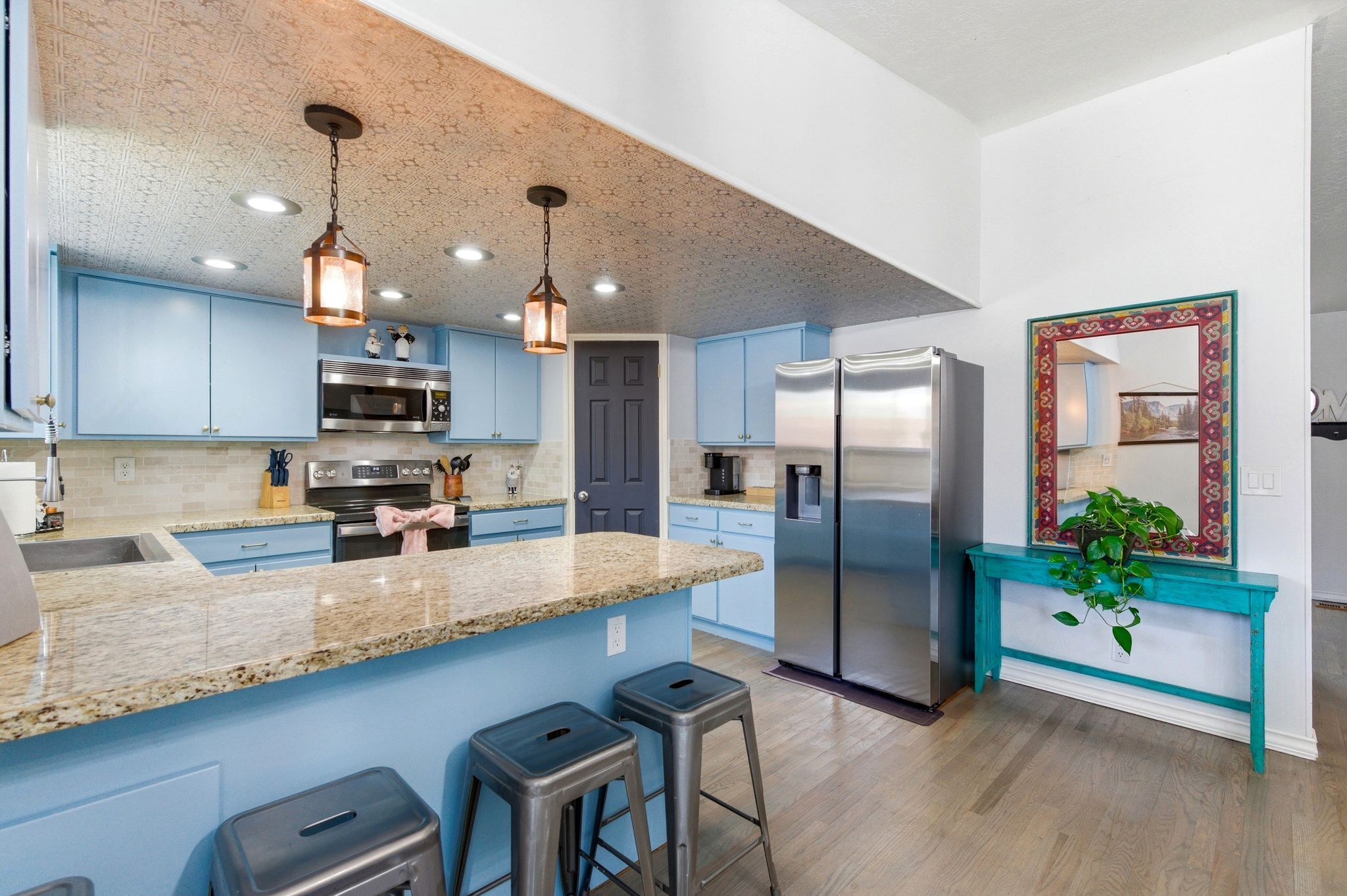 Una cocina moderna con encimeras de granito, electrodomésticos de acero inoxidable y armarios azules.