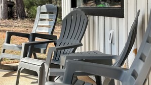 Outdoor seating with Adirondack chairs in front of a building with a window. - The Duck Blind at Cooter Creek Cabins (Elberton)