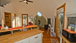 Un'ampia cucina con piani di lavoro in legno, una ventola a soffitto e vista sull'esterno.