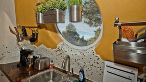 Una cucina con finestra, lavello e diversi utensili.