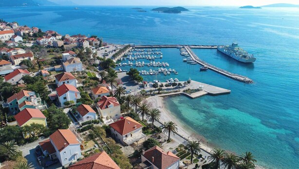 An aerial view of a coastal town with a marina, boats, and a pier. - Great 2-Bedroom Holiday Apartment with terrace and sea-view! (Orebic)