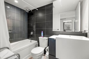A modern bathroom with a bathtub, toilet, and sink. - GLOBALSTAY 1 Bedroom with a Romantic View of Trains in Downtown (Toronto/Canada)