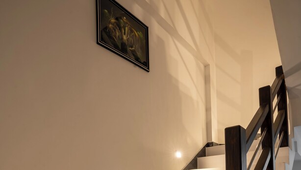A staircase with white steps and a wooden handrail, leading to a landing with a framed artwork. - 10 mins to Surf Point! Newly Renovated Air-Conditioned Balcony Room with WiFi (Matara)