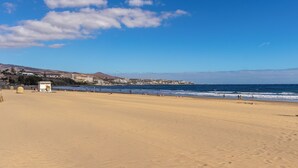 A wide sandy beach with a clear blue sky and ocean waves. - Home2Book Vibrant Maspalomas Stay, Pool & Terrace (Maspalomas)