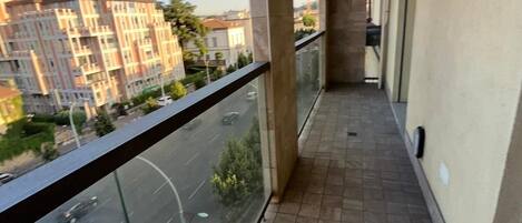 A balcony with a view of a city street and buildings.