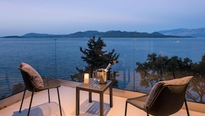 Un balcon avec deux chaises, une table, une bougie et un seau à champagne.