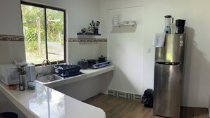 Una cucina moderna con frigorifero in acciaio inossidabile, lavello e finestra.