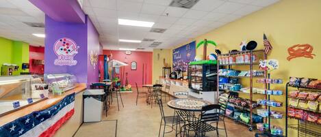 A brightly colored food court with a variety of seating options and food displays.