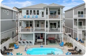 A multi-story residential building with balconies, a pool, and outdoor seating. - Luxurious 6 Brdrm, Private Pool, Islander Resort Access (Ocean Isle Beach)