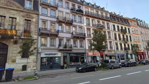 A row of multi-story buildings with various storefronts, including a pharmacy and a hair salon. - Charming studio in the heart of Strasbourg (Strasbourg)