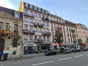 Uma fileira de edifícios altos com diferentes lojas, incluindo uma farmácia e um salão de cabeleireiro.