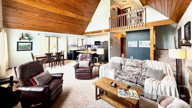 A spacious living area with a high ceiling, a dining table, and a kitchen in the background. - TF26-Quaint Cottage! Pets Ok! Fire Pit! (Davis)