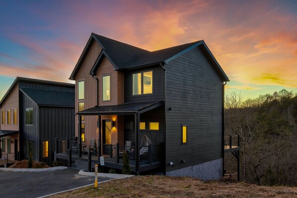 A modern two-story house with a porch, a covered entryway, and a small deck.