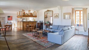 Amplia sala de estar con sofá, una mesa de centro y una zona de comedor con sillas y una mesa.