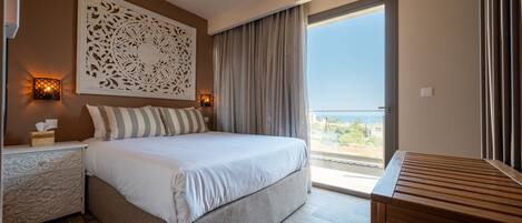 Un dormitorio con cama, lámparas de noche, ventilador de techo, mesa de madera y vistas al exterior.