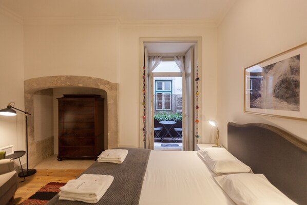 Une chambre d’hôtel équipée d’un lit, d’un bureau, d’une chaise, d’une armoire et offrant une vue sur l’extérieur.