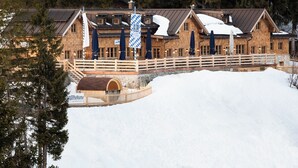 Una cabaña de madera con techo nevado, un muelle de madera y un letrero que dice "BayernKuhle".