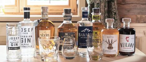A selection of liquor bottles and glasses on a table near a window.