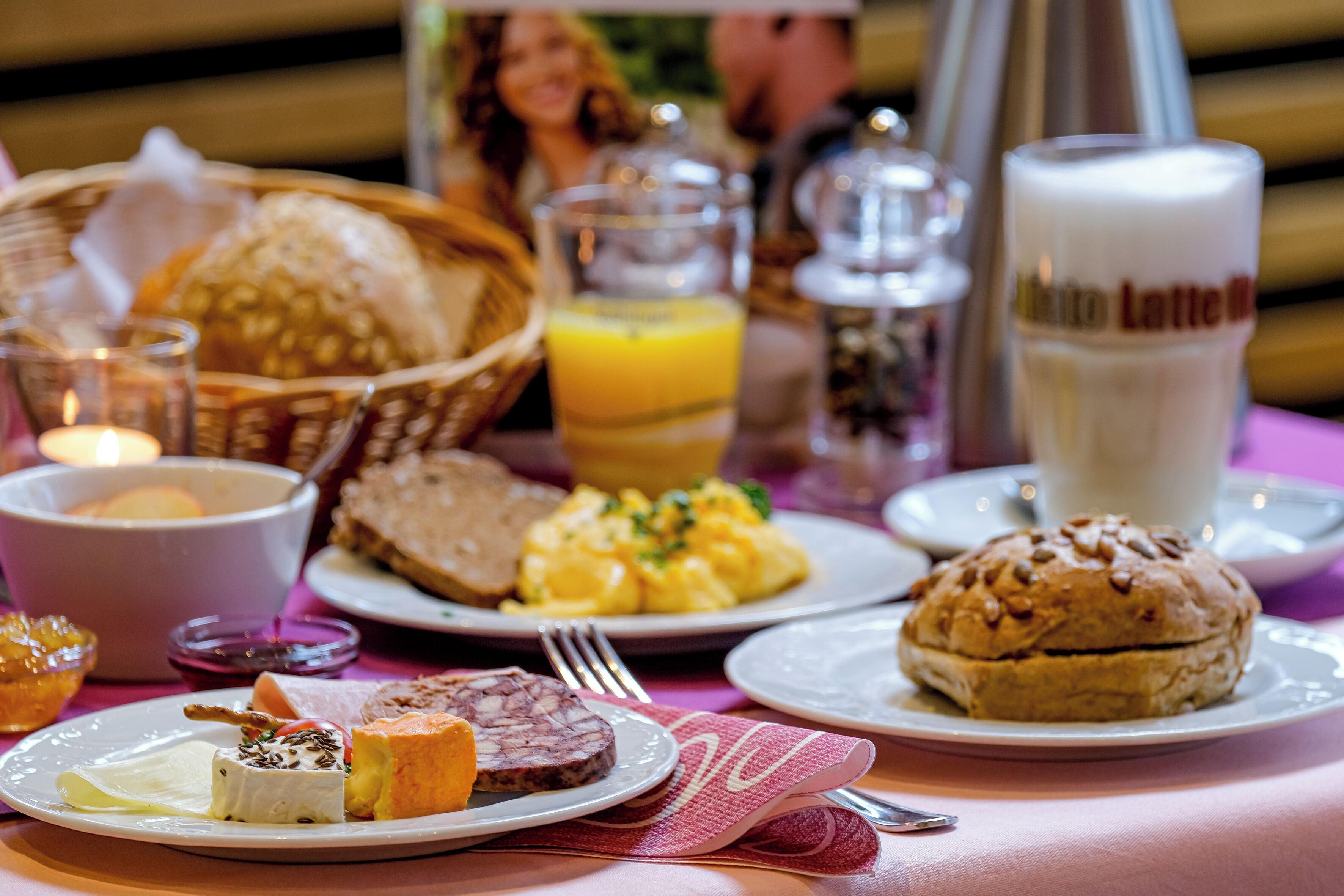A breakfast setting with various dishes, including bread, eggs, and a beverage labeled "Latte."