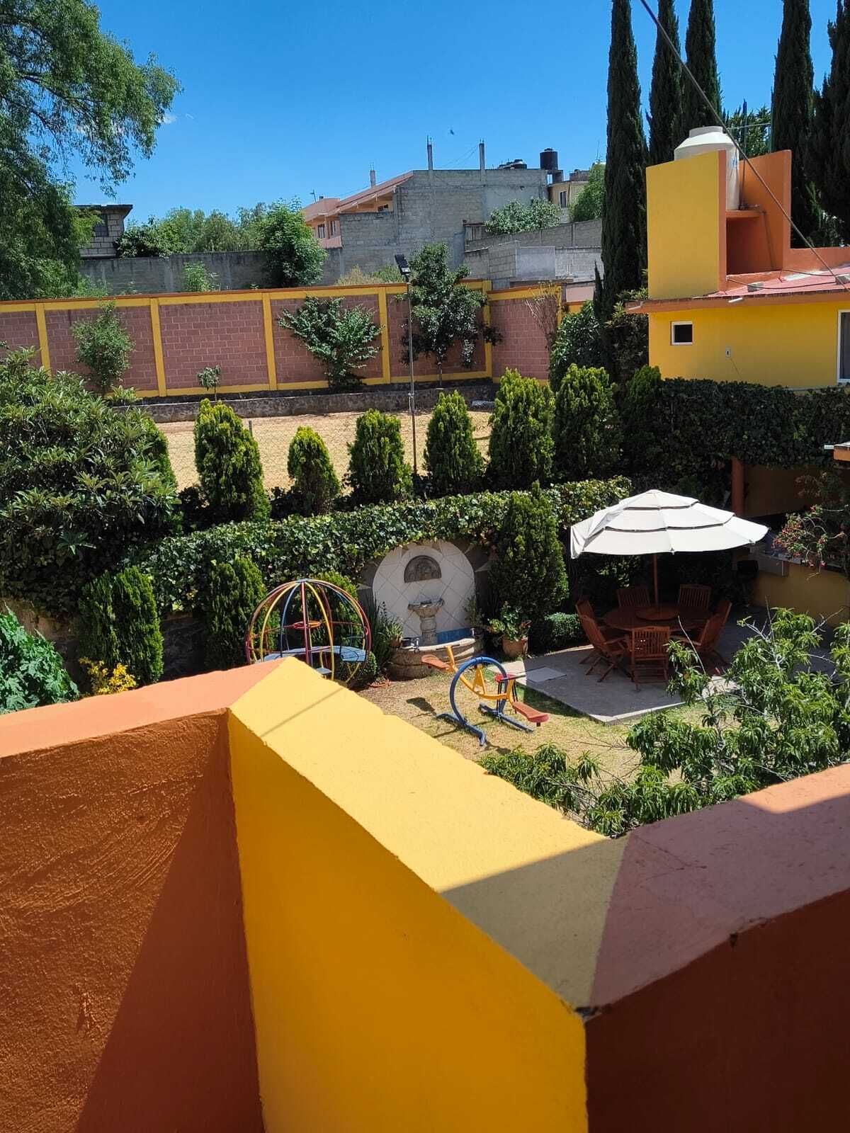 A courtyard with a play area, a seating area, and a view of buildings in the background.