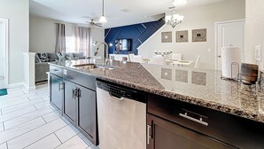 A modern kitchen with granite countertops, stainless steel appliances, and a central island. - Spacious 5BR and 4BA Townhome with Private Pool – 30 Min to Disney & Resorts (Davenport)
