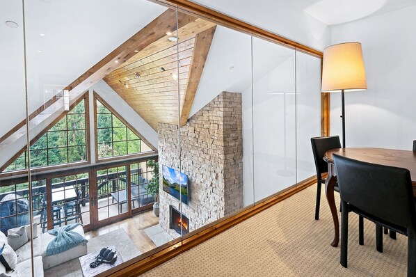 Ein modernes Interieur mit Glaswand, Kamin und Essbereich.