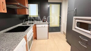 A modern kitchen with granite countertops, a built-in dishwasher, a stove, and a microwave. - Modern apartment only 300 m. from the beach  (Cambrils)