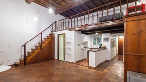 Eine geräumige Küche mit einer Holztreppe, die in eine obere Etage führt.